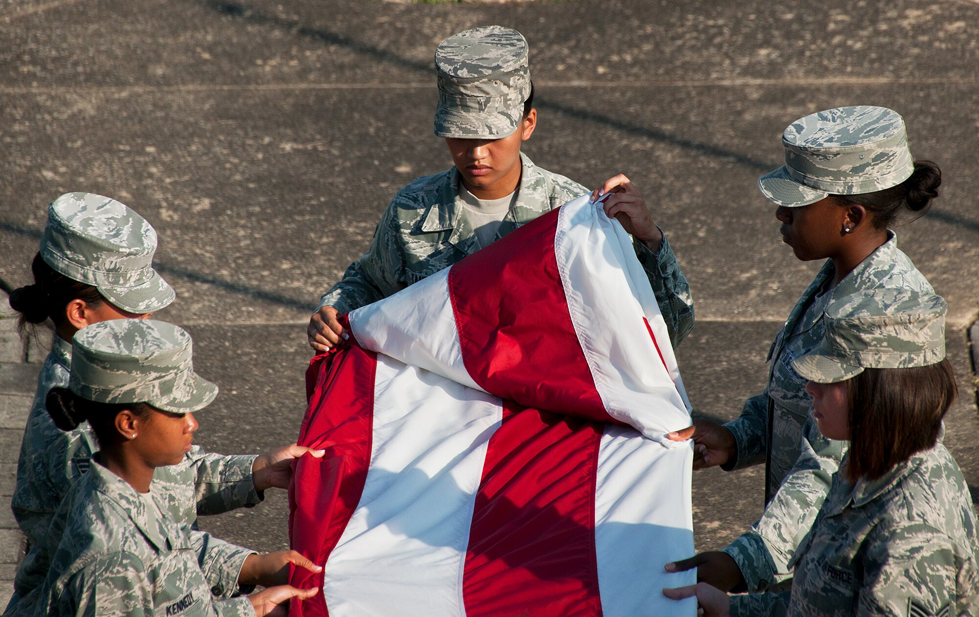 Senior Airman Jessica Tanedo, of the 96th Logistics Readiness Squadron, folds the base flag during a retreat ceremony at Eglin Air Force Base Fla., Aug. 23.  The flight and detail team were all female in honor of Women’s Equality Day.  (U.S. Air Force photo/Samuel King Jr.)
