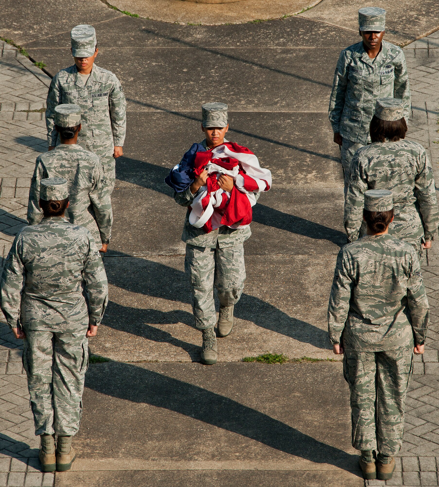Senior Airman Jessica Tanedo, of the 96th Logistics Readiness Squadron, carries the base flag to members of the detail to be folded during a retreat ceremony at Eglin Air Force Base Fla., Aug. 23.  The flight and detail team were all female in honor of Women’s Equality Day.  More than 20 women participated in the event.  (U.S. Air Force photo/Samuel King Jr.)