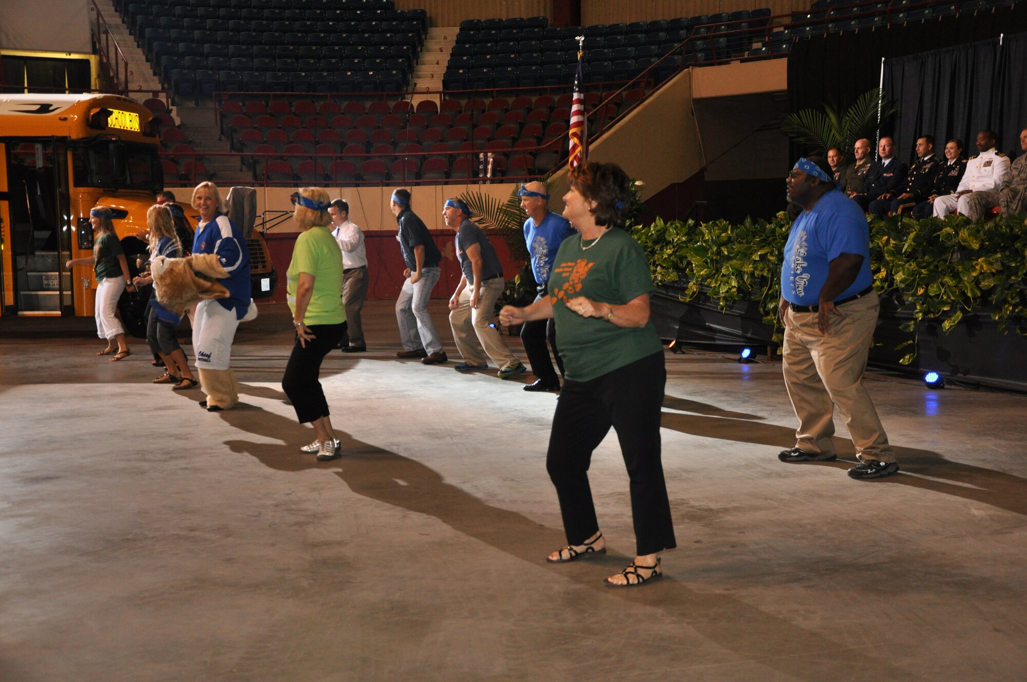 Members from the San Angelo Independent School District perform a dance routine to "Party Rock" at the SAISD Back-to-School convocation Aug. 23. The SAISD members rode into the coliseum on a short school bus and danced out of the bus to perform the routine as a surprise entertainment for the attendees of the event. (Air Force Photo/ Airman 1st Class Erica Flores)