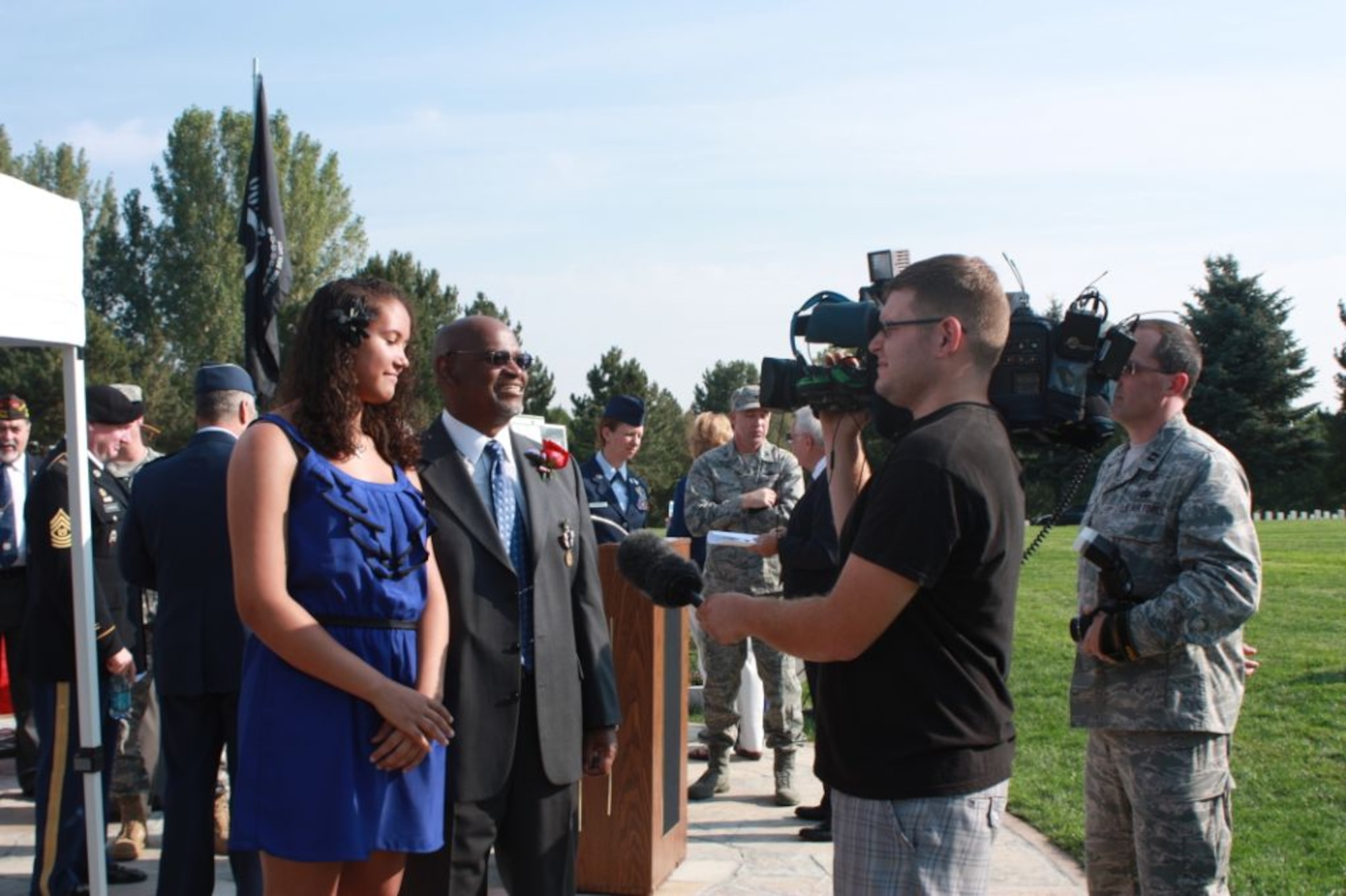 Retired Master Sgt. James Hughes, middle, accompanied by his step-daughter Kalee Maricle-Hughes, left, answers questions to local media after the POW Medal ceremony at Fort Logan National Cemetery, Denver, Colo.,  Aug. 22, 2012. Hughes has been taken as hostage in Iran for 16 days, beginning Nov. 4, 1979 and after 32 years recently received the POW Medal in recognition of his sacrifices. (Courtesy photo/Elaine Buehler)