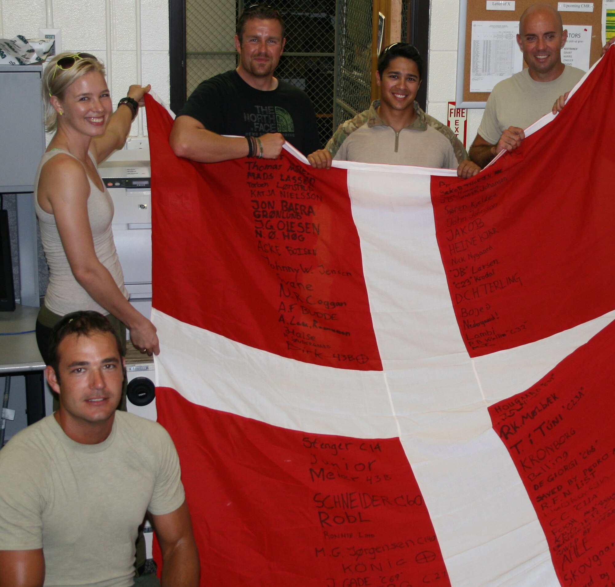 Danish Army Soldiers traveled to the 920th Rescue Wing, Patrick Air Force Base, Fla., to present a signed Danish flag to Guardian Angels who came to their aid when their NATO foot patrol in Afghanistan ended due to life threatening injuries. Clockwise from lower left; Staff Sgt. Darrell “Matt” Williams, 308th RQW, Lance Cpl. Tamara í Túni, Danish Army, Lance Cpl. Karl Stenger, Danish Army,   Senior Airman Kristopher Tomes, 308th RQW, and  Master Sgt. Weston Hufnagel, 30th RQW. (Courtesy photo) 
