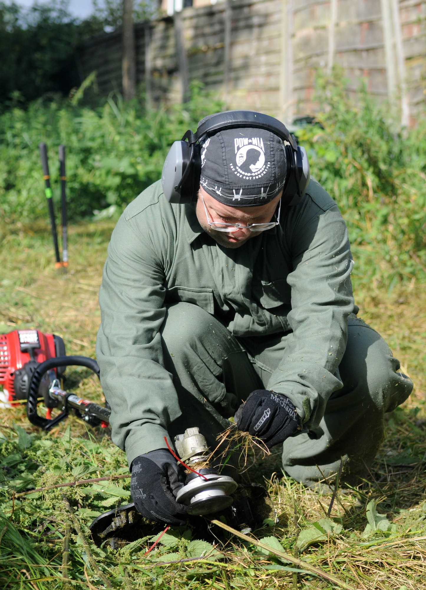 BECK ROW, England – Master Sgt. Eric Leirer, 352nd Special Operations Maintenance Squadron, removes tangled grass from his string trimmer after tackling a huge area of overgrowth in the backyard of a disabled resident in Beck Row, a community just outside RAF Mildenhall, Aug. 25, 2012. Leirer and other volunteers, including his 13-year-old son, took on the task of clearing the yard for the octogenarian homeowner, who was unable to perform the task herself. (U.S. Air Force photo/Staff Sgt. Austin M. May)