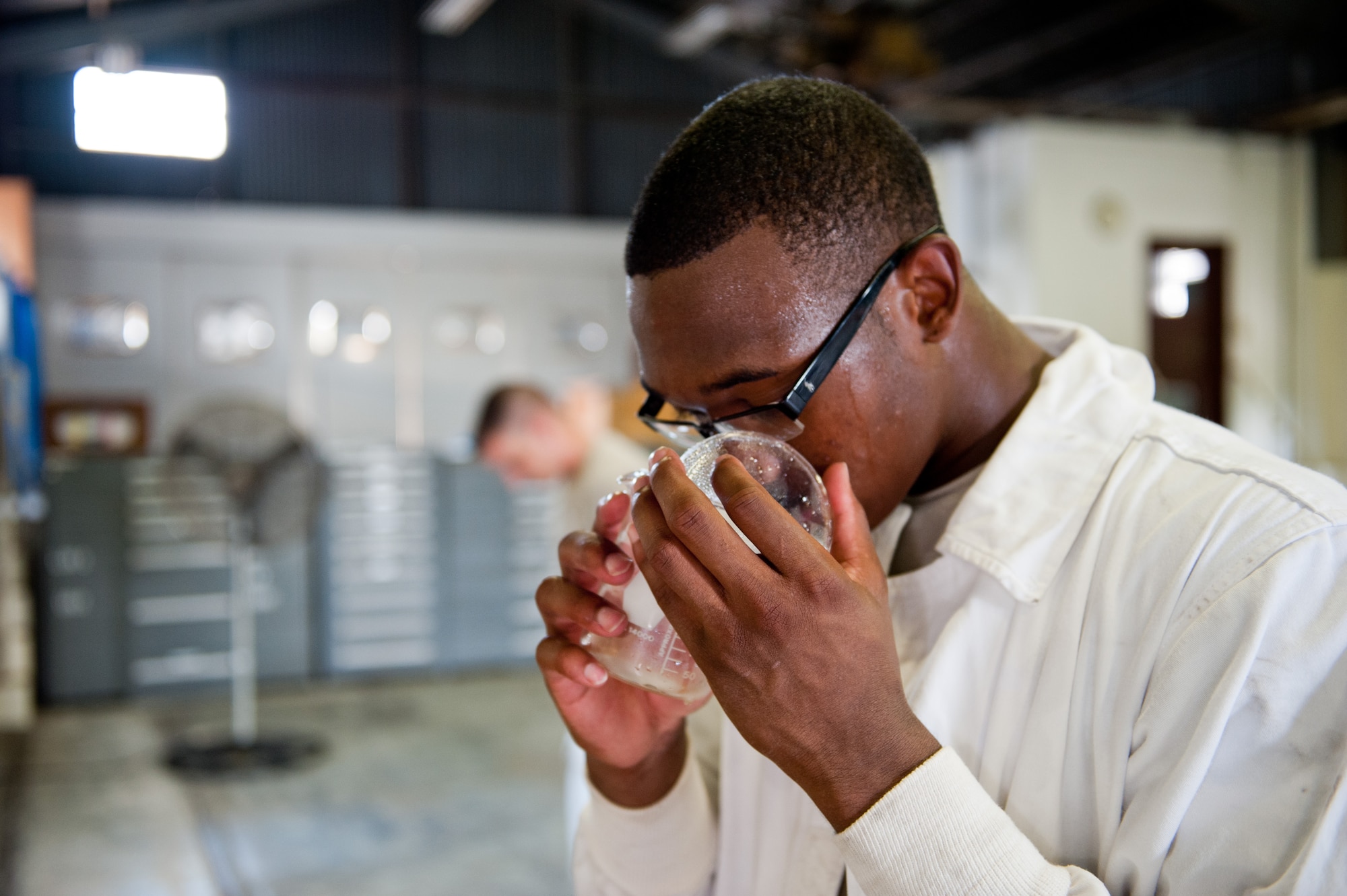 YOKOTA AIR BASE, Japan -- Airman 1st Class Tevin Smith, 374th Logistics Readiness Squadron fuels distribution apprentice, smells a sample of liquid oxygen at Yokota Air Base, Japan, on Aug. 24, 2012. Cryogenic lab personnel smell the LOX to ensure it is at least 99.5 percent pure oxygen. (U.S. Air Force photo by Airman 1st Class John D. Partlow)