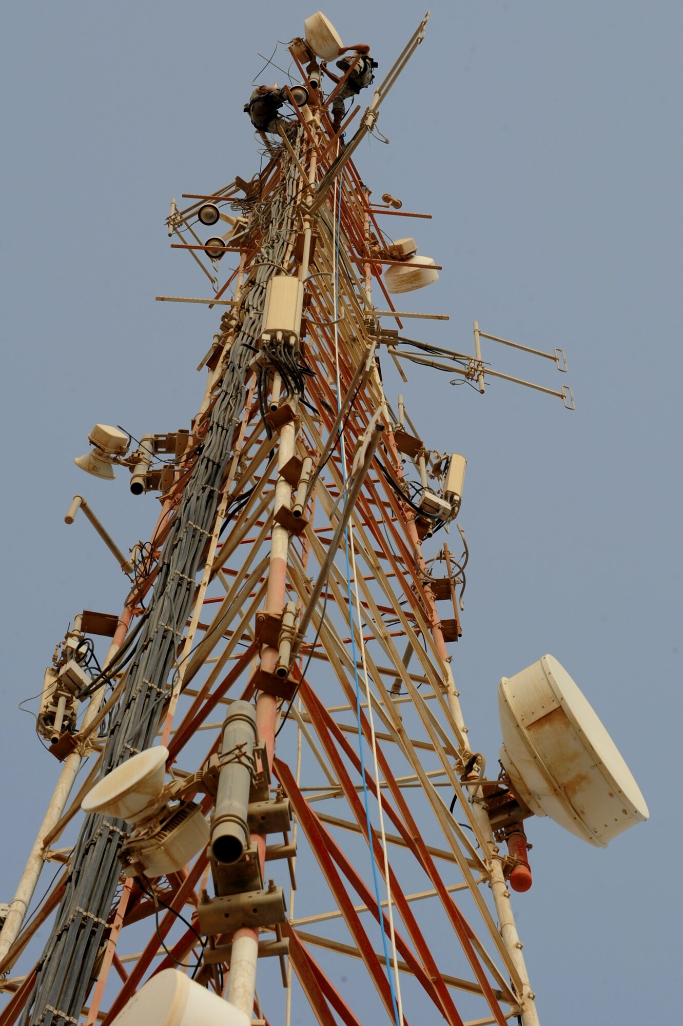 U.S. Air Force Staff Sgt. Levi Hakola (left) and Senior Airman Cyrus Torres, both assigned to the 379th Expeditionary Communication Squadron, scale the 150 foot tall communication tower moving two high frequency ground-to-air antennas in Southwest Asia, August 7, 2012. The move is in preparation for the construction material holding yard for the Technical Control Facility and Network Control Center expansion. Hakola is deployed from Ramstein Air Base, Germany and Torres is from Aviano Air Base, Italy. (U.S. Air Force photo/Staff Sgt. Sheila deVera)
