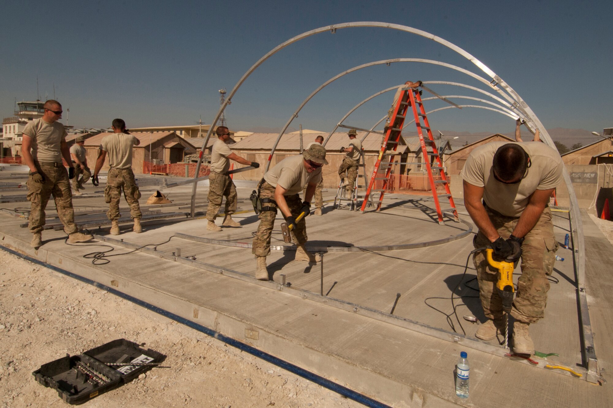A crew of 14 Airmen assigned to the 455th Expeditionary Civil Engineer Squadron assemble the frame work for one of the six Alaska transient tents at Bagram Airfield, Afghanistan, Aug. 22, 2012. The Airmen constructed the tents in two days, working in temperatures above 100 degrees. The tents were built to temporarily house transient Airmen. (U.S. Air Force photo/SSgt Jeff Nevison)