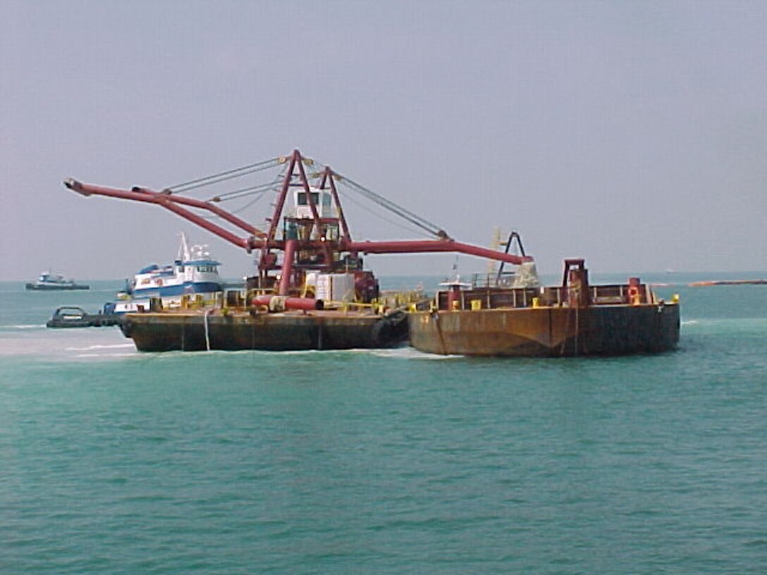 Spider barge loading dredge material onto a scow for transport offshore to the designated Offshore Dredge Material Placement Site.