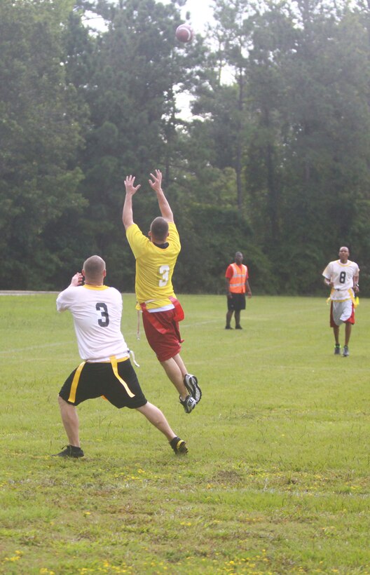 A group of Marines and sailors with 2nd Marine Logistics Group participate in a flag football tournament during a barracks bash aboard Camp Lejeune, N.C., Aug. 22, 2012.  After the tournament, servicemembers enjoyed bouncy houses, rock climbing, sumo wrestling, tug-of-war and a hypnotism show.  The participants also had the opportunity to purchase tickets for raffles to win gift cards, a TV, a DVD player and two bicycles throughout the event. 