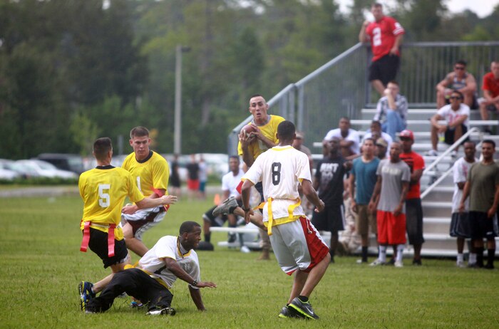 A group of Marines and sailors with 2nd Marine Logistics Group participate in a flag football tournament during a barracks bash aboard Camp Lejeune, N.C., Aug. 22, 2012.  After the tournament, servicemembers enjoyed bouncy houses, rock climbing, sumo wrestling, tug-of-war and a hypnotism show.  The participants also had the opportunity to purchase tickets for raffles to win gift cards, a TV, a DVD player and two bicycles throughout the event. 