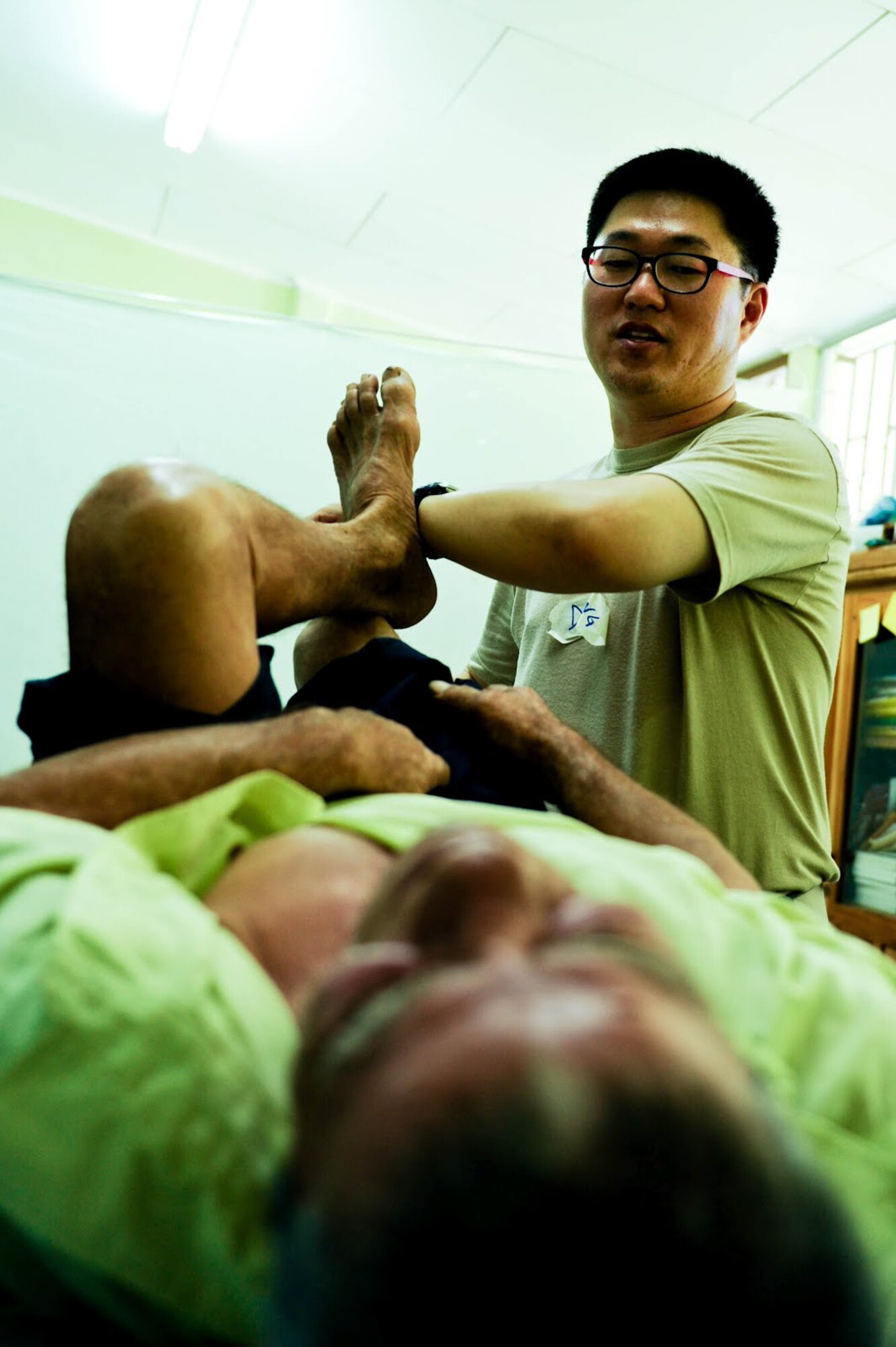 Air Force Maj. John Song, Medical Element Flight Surgeon, shows a Costa Rican patient stretches to alleviate back pain during a two-day joint Medical Readiness Training Exercise. Together with Costa Rica’s Ministry of Health and Social Services, JTF-Bravo delivered medical care to 704 patients.