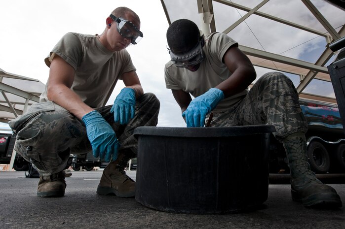 Airman 1st Class Courtney Lewis and Senior Airman Christopher Voogd, 99th Logistics Readiness Squadron fuels lab technician journeymen, check fuels for particulates Aug. 23, 2012, at Nellis Air Force Base, Nev. The sample is used to make sure the fuel is clean, dry, and serviceable. (U.S. Air Force photo by Airman 1st Class Jason Couillard)