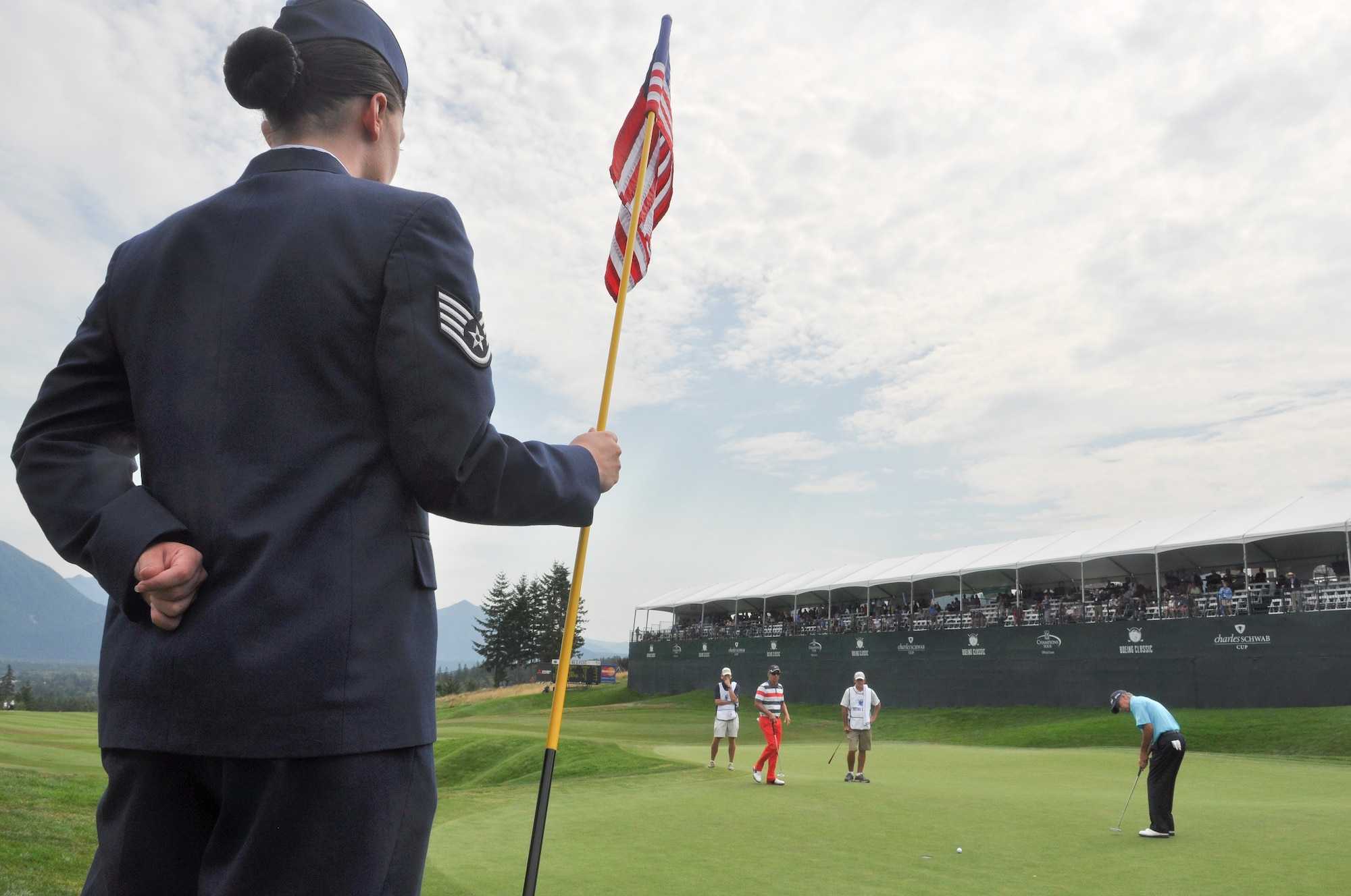 Staff Sgt. Valerie Parra, a jet engine mechanic from the 62nd Aircraft Maintenance Squadron, Joint Base Lewis-McChord, Wash., tends the flag Aug. 26, 2012, off the 18th green of Tournament Player's Club Snoqualmie Ridge golf course in Snoqualmie, Wash. Parra was one of ten U.S. service members selected to perform duties as honorary tee callers and 18th hole flag pullers during Military Appreciation Day at the Boeing Classic tournament held at the course. (U.S. Air Force photo/Staff Sgt. Sean Tobin)