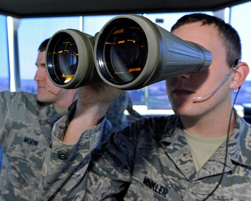 Airman 1st Class Adam Minkler, 92nd Operations Support Squadron air traffic controller apprentice, uses the binoculars to check critical areas on the flightline at Fairchild Air Force Base, Wash., Aug. 28, 2012. The control tower is responsible from the position of each aircraft to wildlife that may have entered the flightline and pose a potential hazard. (U.S. Air Force photo by Airman 1st Class Ryan Zeski)