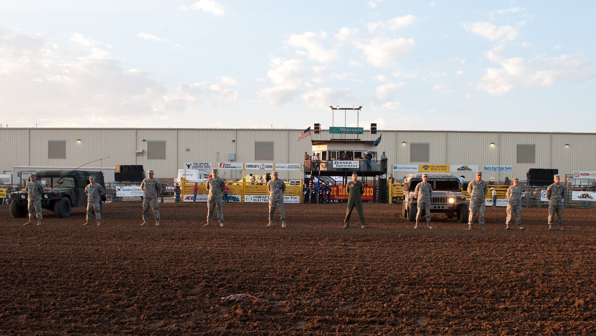 Airmen from Ellsworth Air Force Base and members of South Dakota National Guard stand to be recognized during the Range Days Rodeo at the Central States Fairgrounds in Rapid City, S.D., Aug. 23, 2012. The Annual Pig Roast & Military Appreciation Event, hosted by the Central States Fair and Rapid City Area Chamber of Commerce Military Affairs Committee, was established to honor military members for their sacrifices. (U.S. Air Force photo by Airman 1st Class Alystria Maurer/Released)