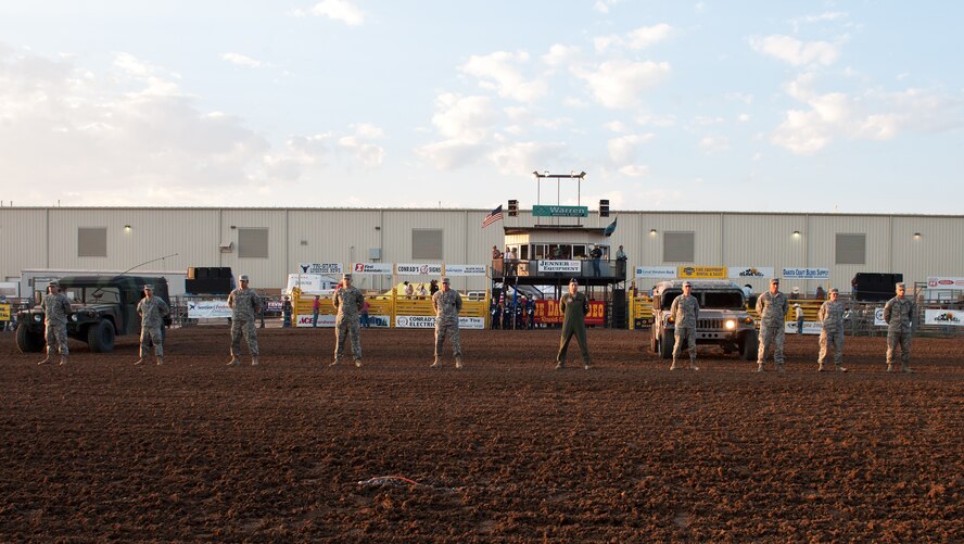 Airmen from Ellsworth Air Force Base and members of South Dakota National Guard stand to be recognized during the Range Days Rodeo at the Central States Fairgrounds in Rapid City, S.D., Aug. 23, 2012. The Annual Pig Roast & Military Appreciation Event, hosted by the Central States Fair and Rapid City Area Chamber of Commerce Military Affairs Committee, was established to honor military members for their sacrifices. (U.S. Air Force photo by Airman 1st Class Alystria Maurer/Released)