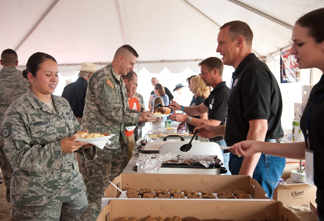 Ellsworth Airmen, South Dakota National Guard soldiers, families and friends enjoy food and festivities during the 26th Annual Pig Roast & Military Appreciation Event at the Central States Fairgrounds in Rapid City, S.D. hosted by the Rapid City Area Chamber of Commerce Military Affairs Committee, Aug. 23, 2012. Five Ellsworth Airmen and five guardsmen were recognized for their service during the event. (U.S. Air Force photo by Airman 1st Class Alystria Maurer/Released)