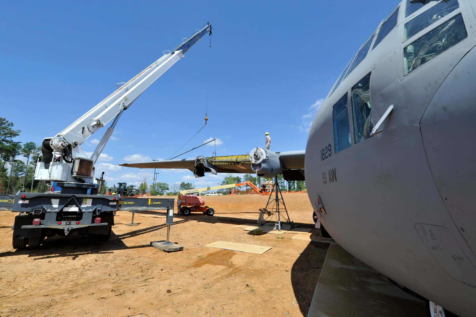 A crane is detached from a wing on a C-130E Aug. 28, 2012, at Jacksonville, Ark. Members of the 19th Civil Engineer Squadron, Component Maintenance Squadron, Aircraft Maintenance Squadron and Equipment Maintenance Squadron at Little Rock Air Force Base worked together to set up the C-130 static display. (U.S. Air Force photo by Staff Sgt. Caleb Pierce)