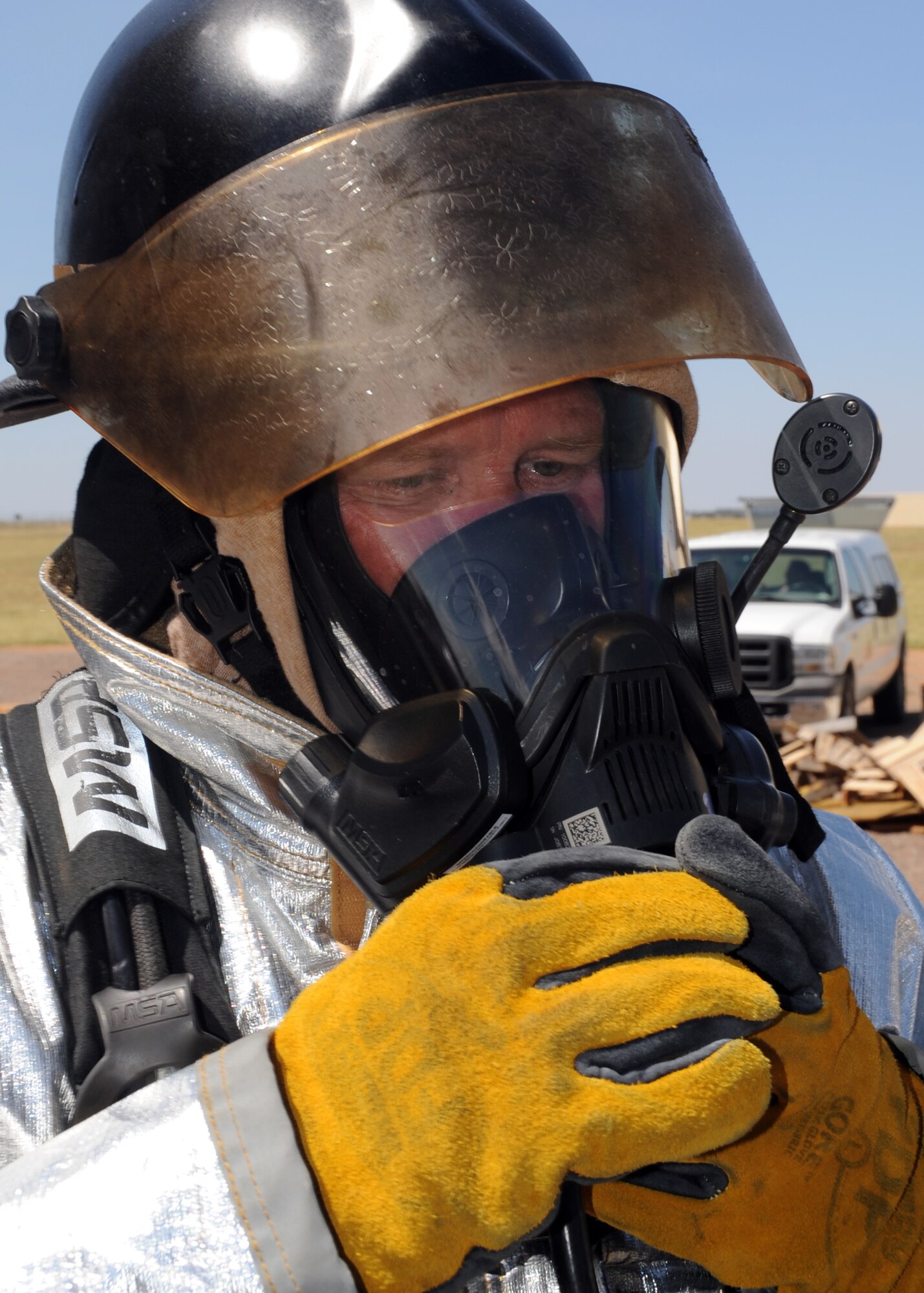 ALTUS Air Force Base, Okla. – Billy Allday, 97th Civil Engineer Squadron fire department fire inspector, attaches an air respirator to his mask before entering the fire flashover simulator at the base training pit, Aug. 28, 2012. The firemen were inspected by Oklahoma State University fire service training instructors to ensure that all equipment worked properly and the all seams were sealed for safety purposes. (U.S. Air Force photo by Airman 1st Class Franklin R. Ramos / 97th Air Mobility Wing / Released)