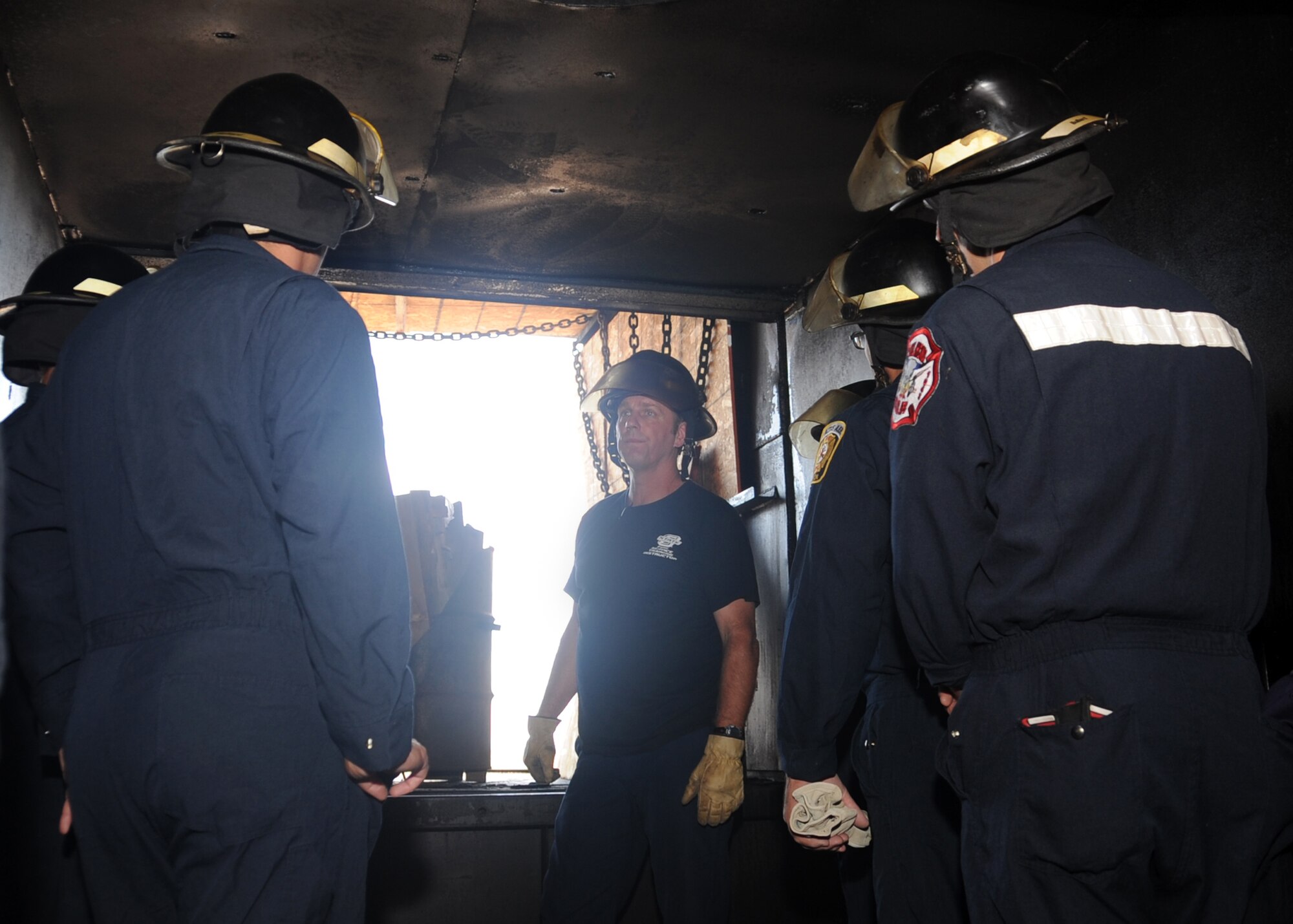 ALTUS Air Force Base, Okla. – Jon Steiner, Oklahoma State University fire service training instructor, briefs members of the 97th Civil Engineer Squadron fire department about advanced fire behavior before a fire flashover exercise at the training pit, Aug. 28, 2012. The exercise was held to teach firefighters how to recognize and escape a room before a fire flashover occurs. (U.S. Air Force photo by Airman 1st Class Franklin R. Ramos / 97th Air Mobility Wing / Released)