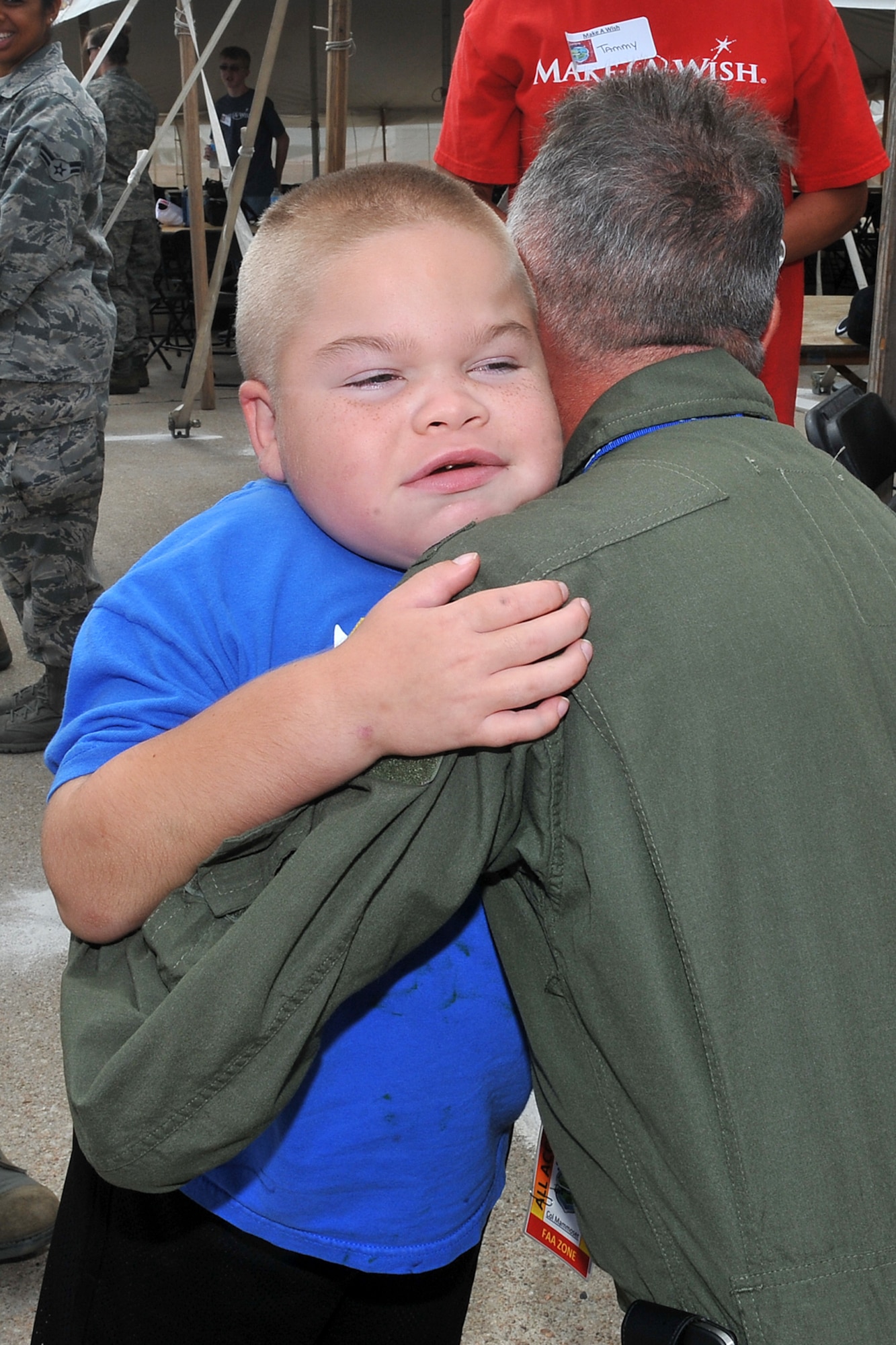 Kane True hugs U.S. Air Force Col. Russell Mammoser, 55th Operations Group commander, during the 2012 Defenders of Freedom Special Needs Air Show on Offutt Air Force Base, Neb., Aug. 24. Guests to the Defenders of Freedom Open House and Air Show were treated to many static display aircraft, booths and vendors during the two-day show. (U.S. Air Force photo by Charles Haymond/Released)