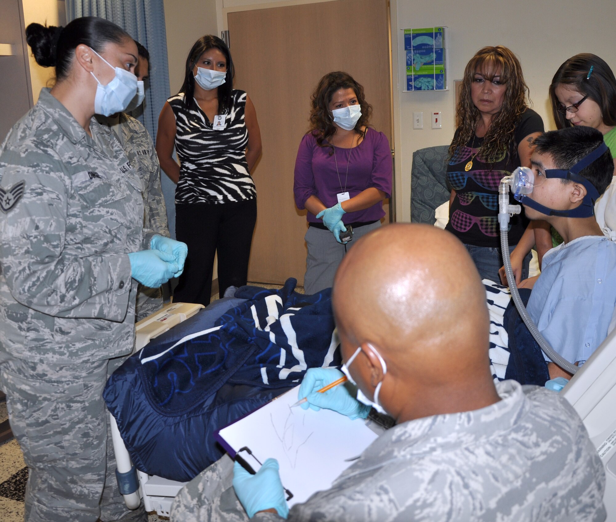 SAN ANGELO, Texas--  Master Sgt. Marvin Hawkins, 17th Medical Operations Squadron, draws a photo of a jet for Javier, 16, at the Shannon Medical Center Aug. 23. Javier, who has a terminal illness, was later presented with a certificate making him an honorary Airman and a command chief’s coin. (U.S. Air Force photo/Airman 1st Class Jessica Keith) 