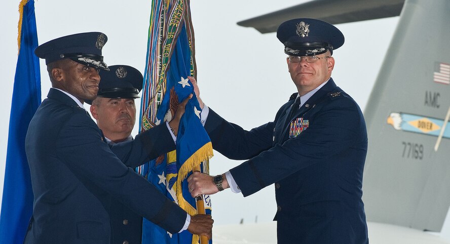 Lt. Gen. Darren McDew, left, 18th Air Force commander, passes the 436th Airlift Wing guidon to Col. Richard Moore, Jr., the incumbent wing commander, during the 436th AW change of command ceremony August 27, 2012, in Hangar 706 at Dover Air Force Base, Del. Col. Mark Camerer relinquished command of the wing to Moore during the ceremony. (U.S. Air Force photo by Roland Balik)