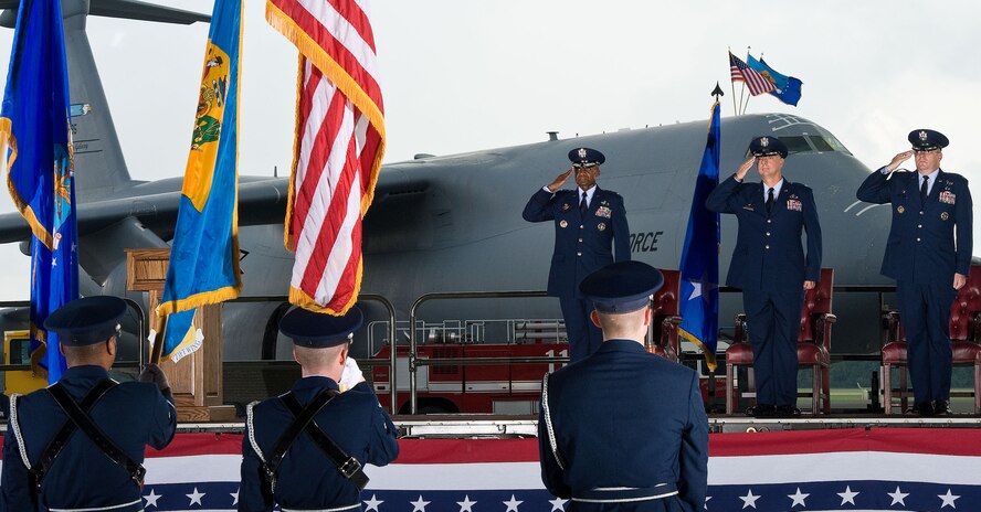 Lt. Gen. Darren McDew, center background, 18th Air Force commander, Col. Mark Camerer and Col. Richard Moore, Jr., render salutes during the 436th Airlift Wing change of command ceremony August 27, 2012, in Hangar 706 at Dover Air Force Base, Del. Camerer relinquished command of the wing to Moore during the ceremony. (U.S. Air Force photo by Roland Balik)