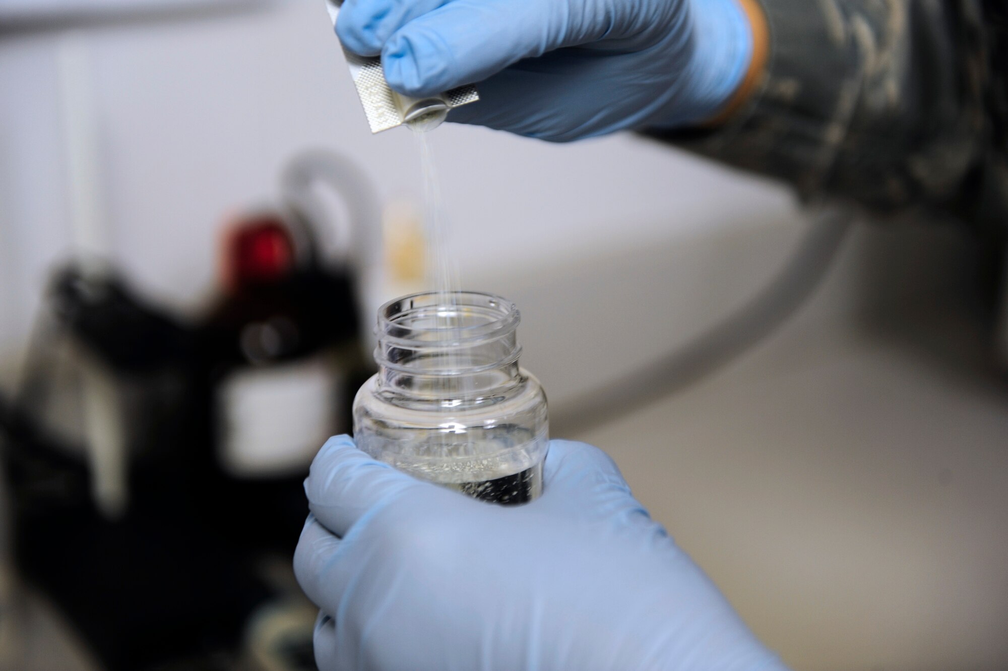 Airman 1st Class Amber Ubinger, 20th Aerospace Medical Squadron bioenvironmental technician, pours a revealing agent into a water sample for testing at Shaw Air Force Base, S.C., Aug. 17, 2012. When incubated, the revealing agent may turn different colors, indicating whether or not there is contamination present within the sample. This is one of many tests used to ensure Shaw’s water is safe for use and consumption. (U.S. Air Force photo by Airman 1st Class Daniel Blackwell/Released)