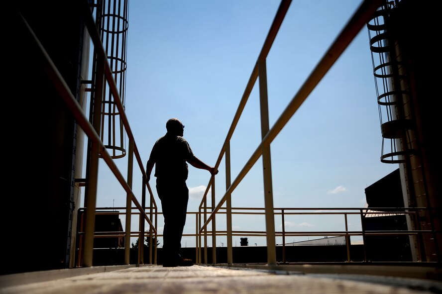 WHITEMAN AIR FORCE BASE, Mo. -- Paul Ross, 509th Civil Engineer Squadron central heat plant project manager, performs a routine inspection of the central heat plants emergency fuel tanks, Aug. 27. During the inspection Ross examines the tanks in search of leaking oil, cracks and anything that could potentially cause a major fuel spill on base. (U.S. Air Force photo/Senior Airman Nick Wilson) (Released)