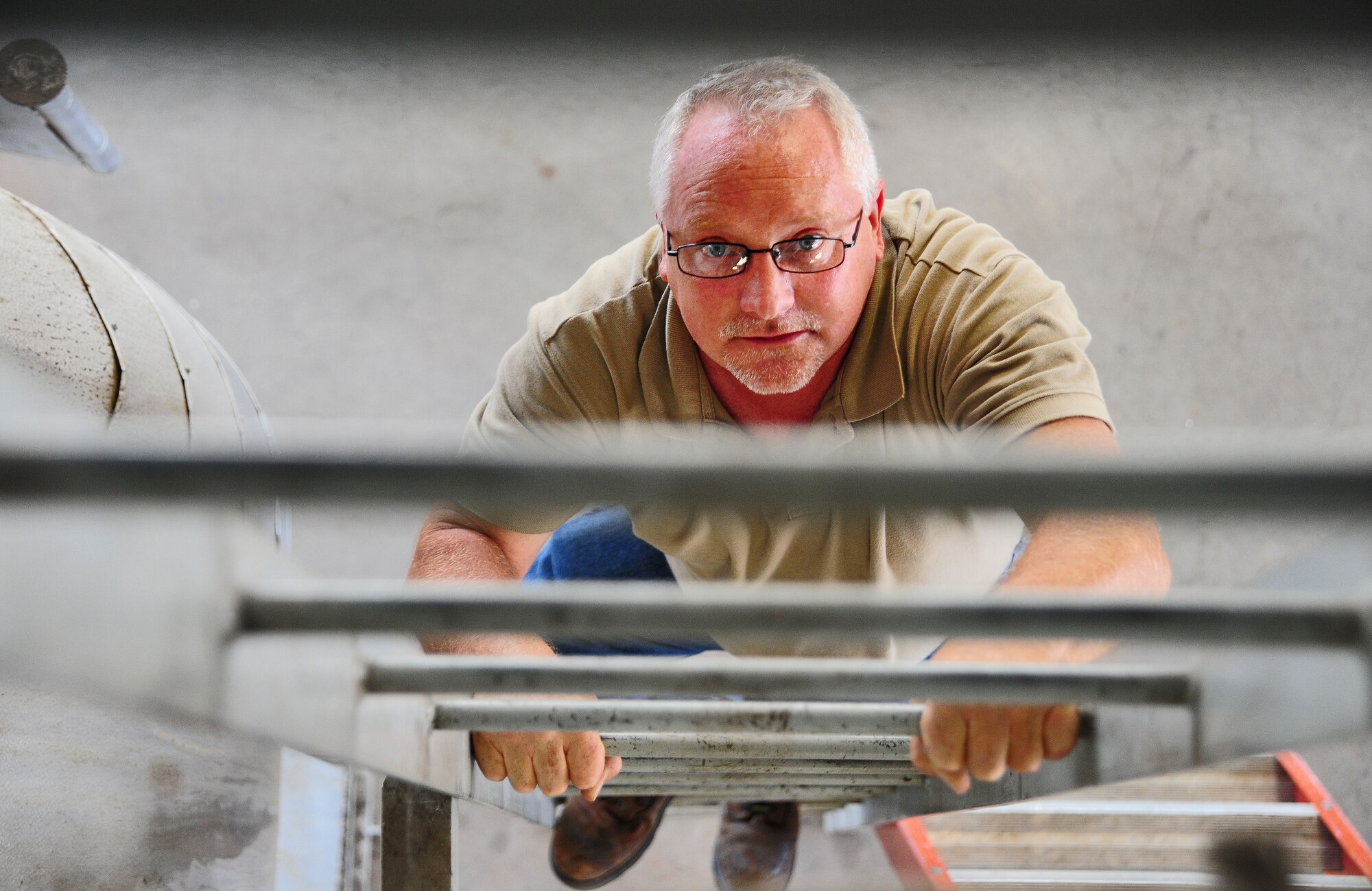 WHITEMAN AIR FORCE BASE, Mo. -- Paul Ross, 509th Civil Engineer Squadron central heat plant project manager, climbs a ladder before visually inspecting the exterior of a dearation tank, Aug. 27. The tank removes air and non-condensable gases from water to prevent corrosion in the boilers. (U.S. Air Force photo/Senior Airman Nick Wilson) (Released)