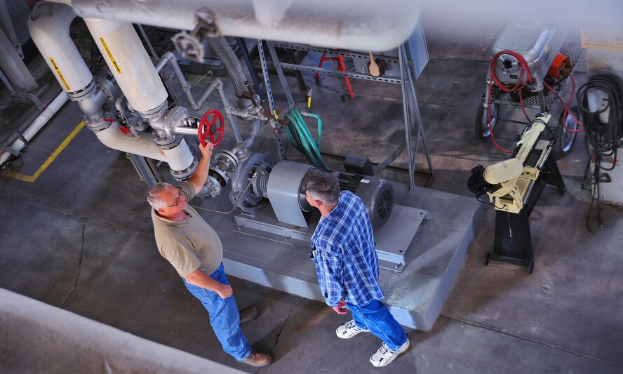 WHITEMAN AIR FORCE BASE, Mo. -- Paul Ross, 509th Civil Engineer Squadron central heat plant project manager, and John Goff, 509th CES boiler operator, discuss a centrifugal pump’s operational procedures, Aug. 27. The 50-horsepower pump is used to distribute water for use in the heat plant’s boilers. (U.S. Air Force photo/Senior Airman Nick Wilson) (Released)