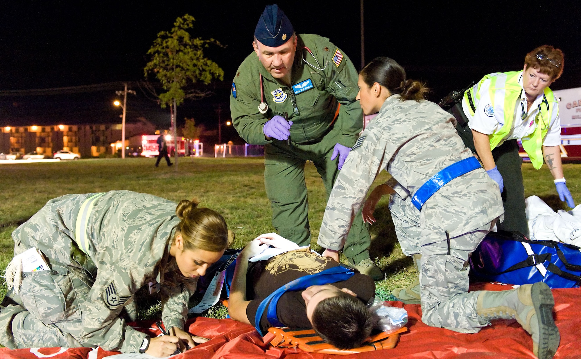 Military and civilian first responders triage a simulated victim Aug. 21, 2012, at Dover Air Force Base, Del. A simulated explosion at the base theater was part of the Aug. 20-22 Major Accident Response Exercise, held to test Team Dover?s ability to respond to threats and emergencies. Dover AFB partnered with members of the local community during the MARE to strengthen cooperation and communication between agencies. (U.S. Air Force photo by Roland Balik)