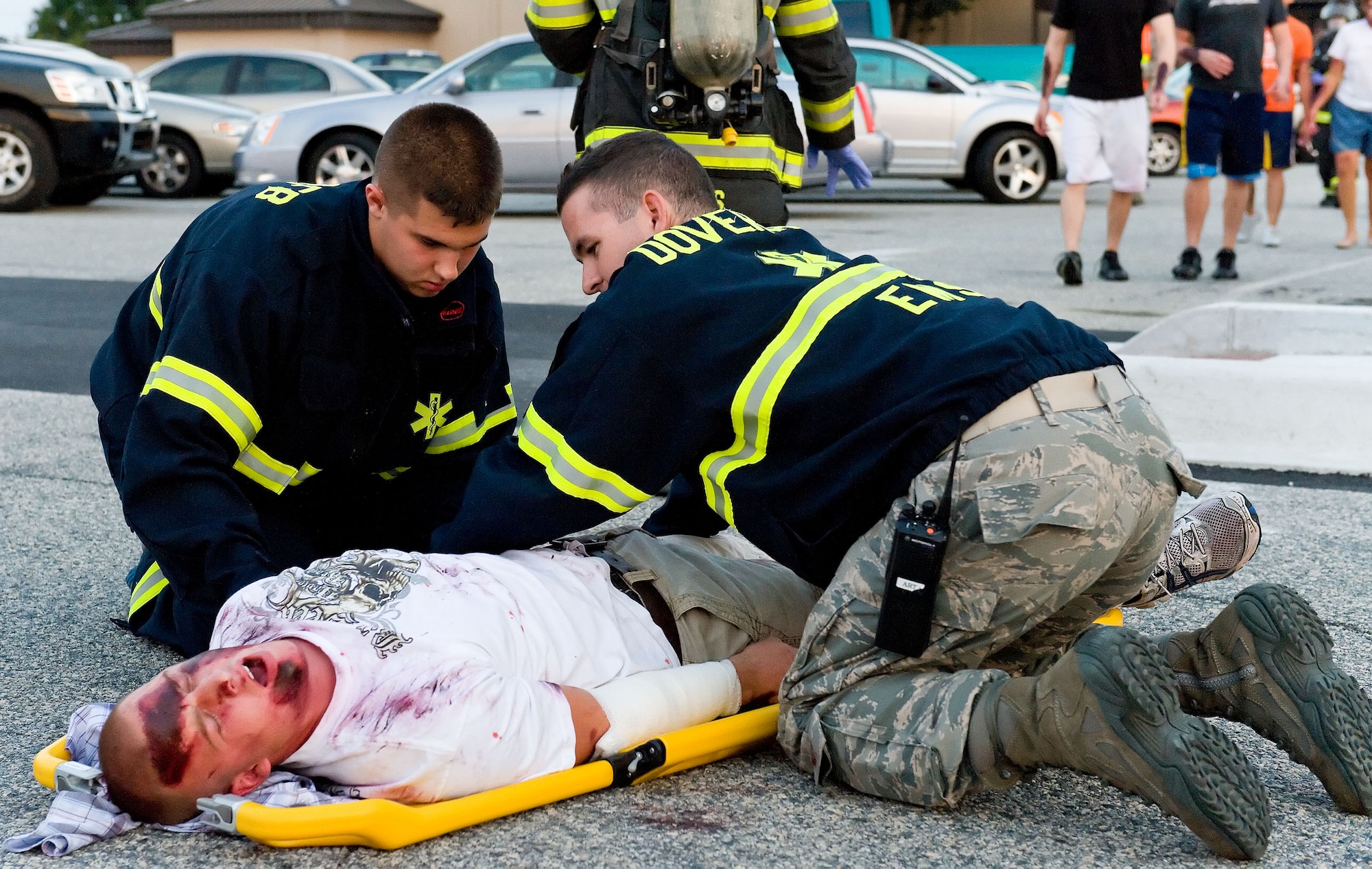 First responders from the 436th Medical Group prepare to transport a simulated victim Aug. 21, 2012, at Dover Air Force Base, Del. A simulated explosion at the base theater was part of the Aug. 20-22 Major Accident Response Exercise, held to test Team Dover?s ability to respond to threats and emergencies. Dover AFB partnered with members of the local community during the MARE to strengthen cooperation and communication between agencies. (U.S. Air Force photo by Roland Balik)