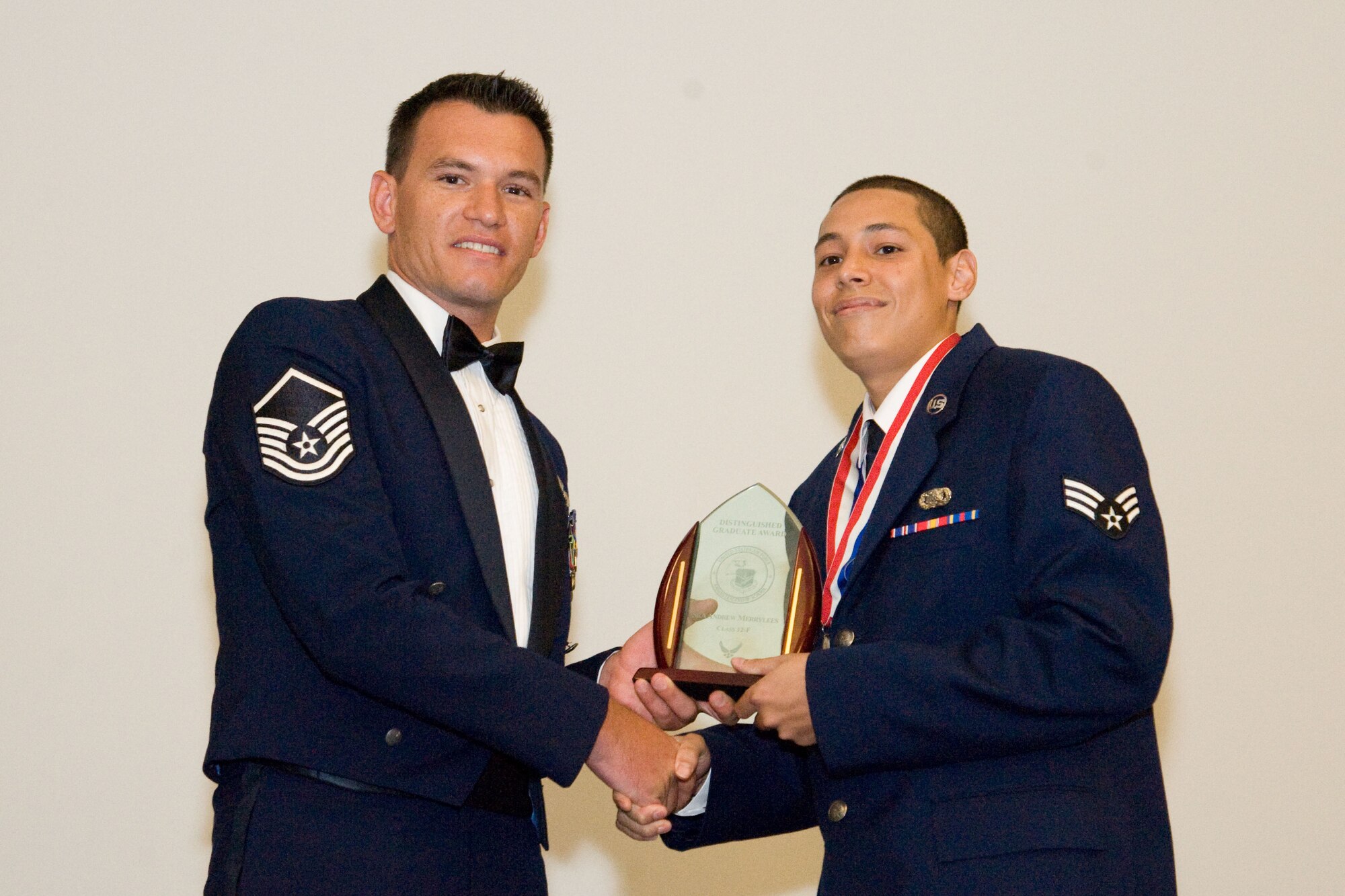Master Sgt. Kurt Nemecek, 9th Airlift Squadron, left, presents the Distinguished Graduate award to Senior Airman Andrew Merrylees, 142nd Airlift Squadron, 166th Airlift Wing, Delaware Air National Guard, on Aug. 16, 2012, at the conclusion of the in-residence Airman Leadership School held from July to August at Dover Air Force Base, Del. (U.S. Air Force photo/Adrian Rowan)
