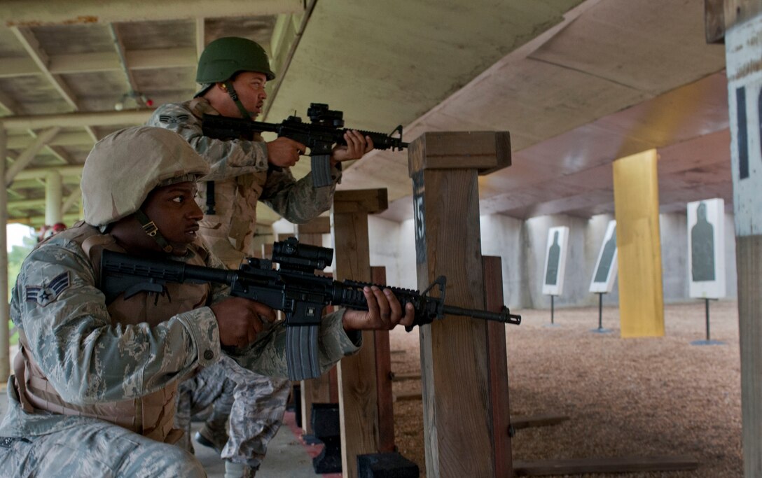 U.S. Air Force Senior Airman Prince Levy and Senior Airman Philip Carrington, Airmen with the 633rd Communications Squadron, practice rapid reload techniques during the Combat Arms course at Langley Air Force Base, Va., Aug. 28, 2012. The course consists of two phases: classroom and live fire. (U.S. Air Force photo by Senior Airman Stephanie Rubi/Released) 