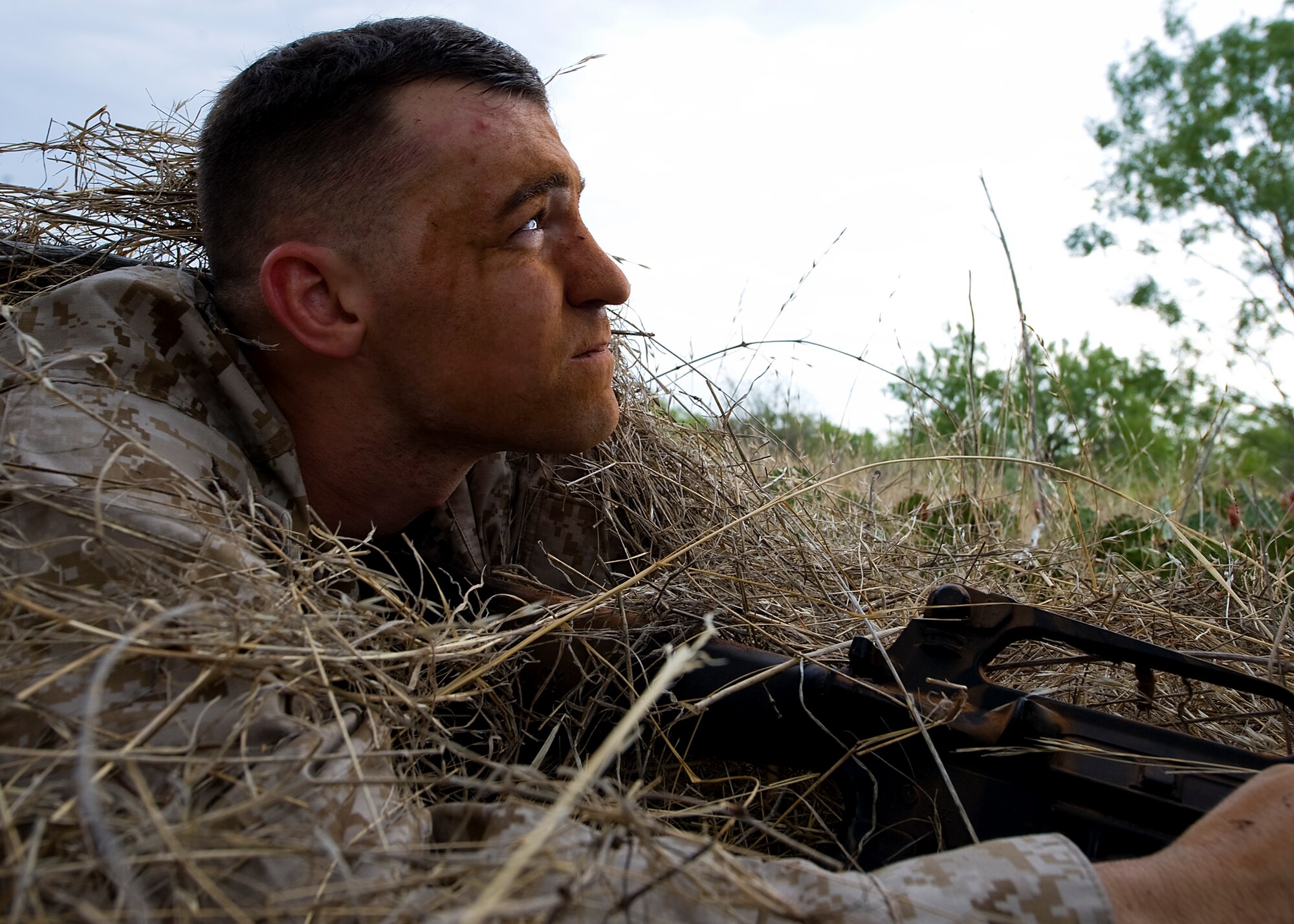 U.S. Marines Corps Cpl. Daniel Ranspot, Corporals Course student, lays in the prone firing position underneath dead grass during the culminating portion of the Corporal’s Course Aug. 24, 2012, at Dyess Air Force Base, Texas. The Corporals Course is a two-week program focused on providing the skills necessary to lead Marines and is designed to provide the war fighting skill, core values and mindset necessary for effective leadership of a team and subordinate Marines. Upon completion, corporals have the skills necessary to clearly articulate one’s thoughts in both oral and written communications; understand the standards of leadership traits, principles and fundamentals; understand the NCO mindset of "doing instead of knowing;" and execute and apply tactical measures at the team level. (U.S. Air Force photo by Airman 1st Class Damon Kasberg/Released)