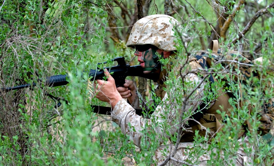 A U.S. Marine Corporals Course student, hides under cover during the final exercise of the Corporals Course Aug. 24, 2012, at Dyess Air Force Base, Texas. The Corporals Course is focused on providing the skills necessary to lead Marines and is designed to provide the war fighting skill, core values and mindset necessary for effective leadership of a team and subordinate Marines. (U.S. Air Force photo by Airman 1st Class Charles V. Rivezzo/ Released)