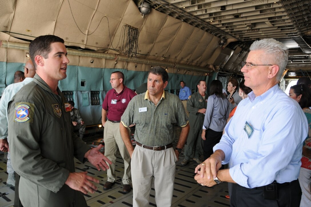 Tech Sgt. David Fink (left) of the 433rd Airlift Wing, Joint Base San Antonio, talks about his job as a C-5 Galaxy loadmaster Thursday to Matt Turlinski, chairman of the Rehoboth Beach (Del.)-Dewey Beach (Del.) Chamber of Commerce (center) and Joseph Swiski, chief of administration for the Delaware Department of Safety and Homeland Security. The men were among 29 civic leaders on an overnight tour to Texas. (U.S. Air Force photo by Chief Master Sgt. Matt Proietti)