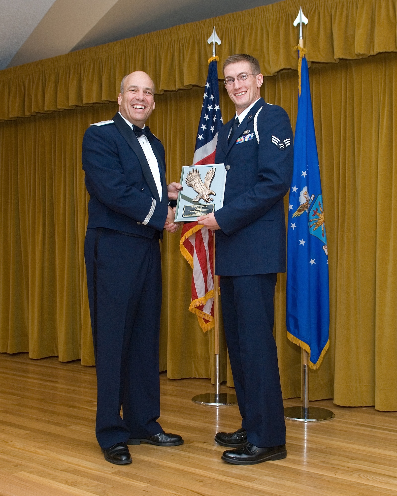 Brig. Gen. Michael T. Brewer, 412th Test Wing commander (left), presents Senior Airman Gregory Evenson of the 12th Combat Training Squadron out of Fort Irwin, Calif., with the John L. Levitow Award during the Airman Leadership School graduation ceremony held at Club Muroc Aug. 23.  The award is given to the class's top graduate and is named after Vietnam War Medal of Honor awardee Sergeant John L. Levitow.  ALS Class 12-F graduated 21 Airmen. The 12th CTS at Ft. Irwin runs the Green Flag training exercise, which is Air Combat Command's premiere air-to-ground attack training exercise.  They also support Army units.  Evenson is a Battlefield Weather Airman who provides weather support to Army training units at Ft. Irwin. (U.S. Air Force photo by Edward Cannon)