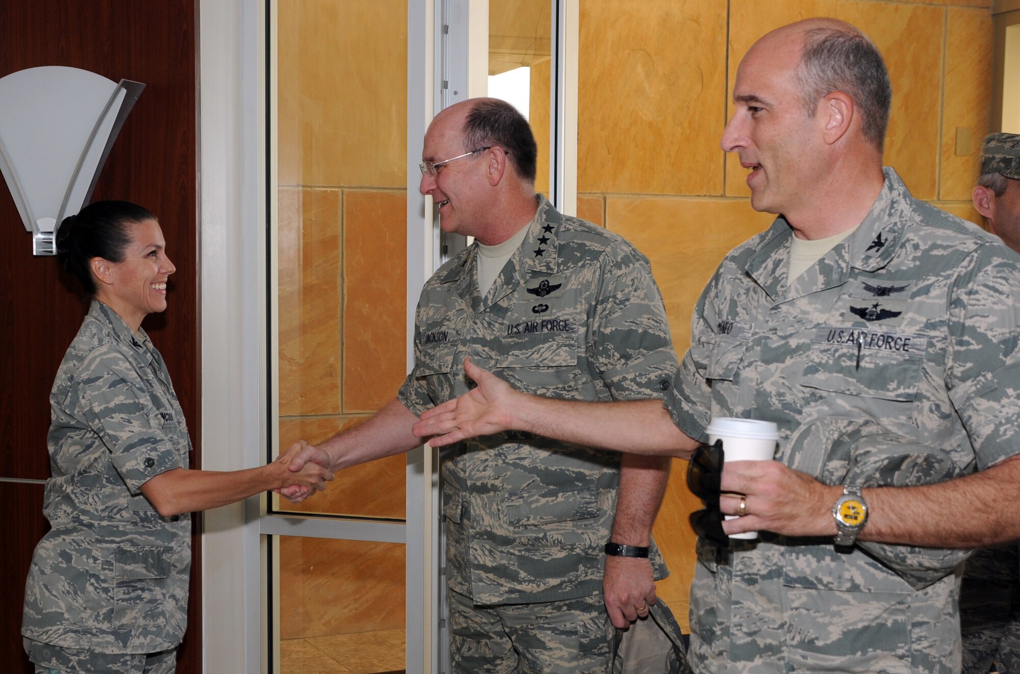 Lt. Gen. James Jackson (middle), Air Force Reserve Command commander, shakes the hand of Col. Pamela Lincoln, 310th Space Wing vice commander, as Col. Jeffrey Mineo (right), 310 SW commander, leads the way during the general's visit Aug. 28 at the wing headquarters on Schriever Air Force Base. (U.S. Air Force photo/Staff Sgt. Julius Delos Reyes)