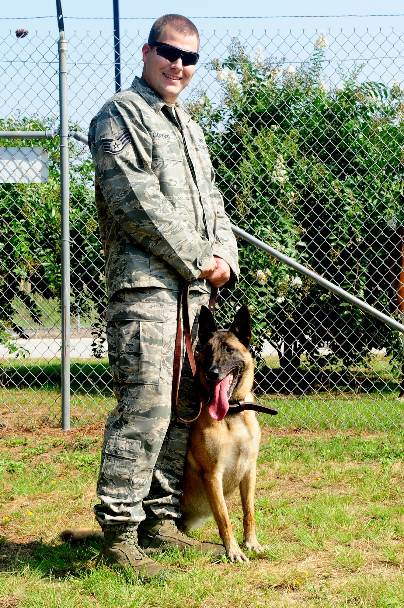 U.S. Air Force Staff Sgt.  Johnathan Cooper, 20th Security Forces Squadron canine handler, poses with Military Working Dog Astra at Shaw Air Force Base, S.C., Aug. 17, 2012. All MWDs from every branch of the military are sent to Lackland Air Force Base, Texas for fundamental training. (U.S. Air Force photo by Airman 1st Class Hunter Brady/Released)