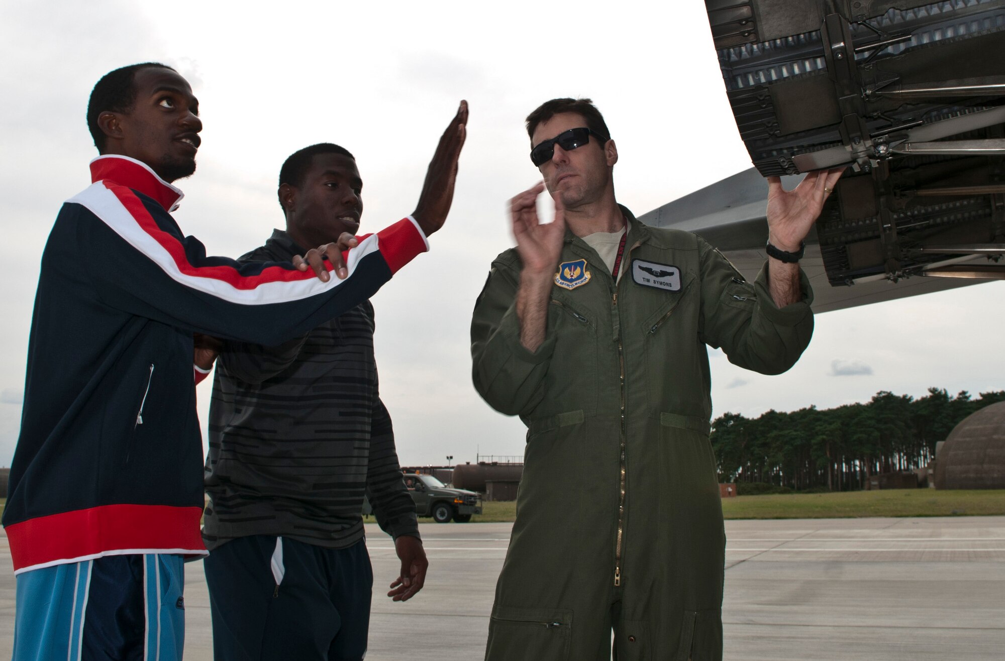 ROYAL AIR FORCE LAKENHEATH, England - Lex Gillette (left), U.S. Paralympian, is guided by his trainer Wes Williams, to touch an F-15C Eagle aircraft on the flightline as Capt. Timothy Symons, 48th Operations Group executive officer, gives him the description of the engine, Aug. 23, 2012. Gillette is competing in the 100m and 200m race and the 4x100m relay, triple jump, and the long jump, which he holds the world record in.  More than 50 U.S. Paralympians and hopefuls honed their skills and made final preparations here Aug. 18 through 25 for competition in the London 2012 Paralympic Games. (U.S. Air Force photo by Senior Airman Connor Estes)