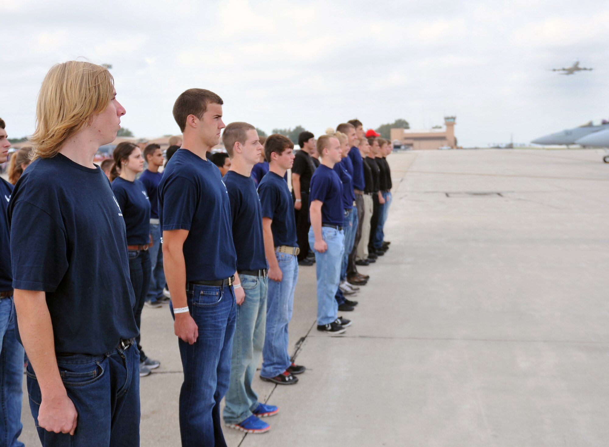 New recruits stand at attention as they are honored with a fly-by at the 2012 Defenders of Freedom Open House and Air Show ont Offutt Air Force Base., Neb., Aug. 26. Local area high school students going into all branches of the military were sworn in by an A-10 Thunderbolt II pilot in front of thousands of air show attendees. (U.S. Air Force photo by Jeff W. Gates/Released)
