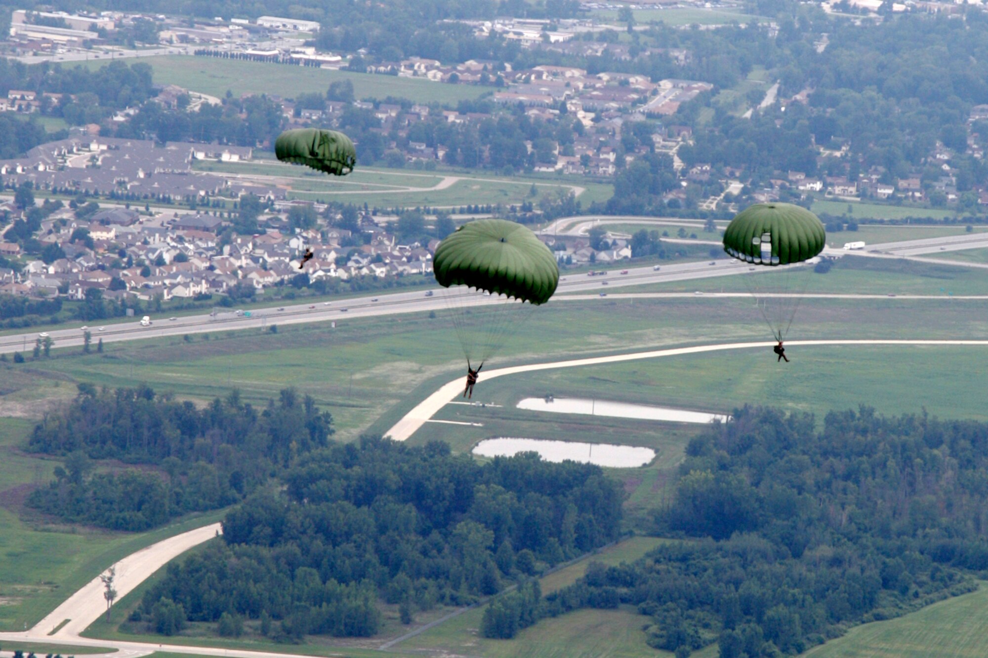 Soldiers and Airmen from the Indiana Army National Guard and Michigan Air National Guard perform a parachute drop over Selfridge Air National Guard Base, Mich., Aug. 13, 2012. During the jump, the Soldiers and Airmen are able to control their canopy to enable them to land in a targeted location. The Soldiers and Airmen spent a day conducting joint airborne operations, with each individual making several parachute jumps during the day. The training allowed the Soldiers and Airmen to maintain their proficiency in a variety of skill requirements. By training together, the Soldiers and Airmen are able to maximize training opportunities at a lower cost. (Air National Guard photo by SrA. Toni Stusse)