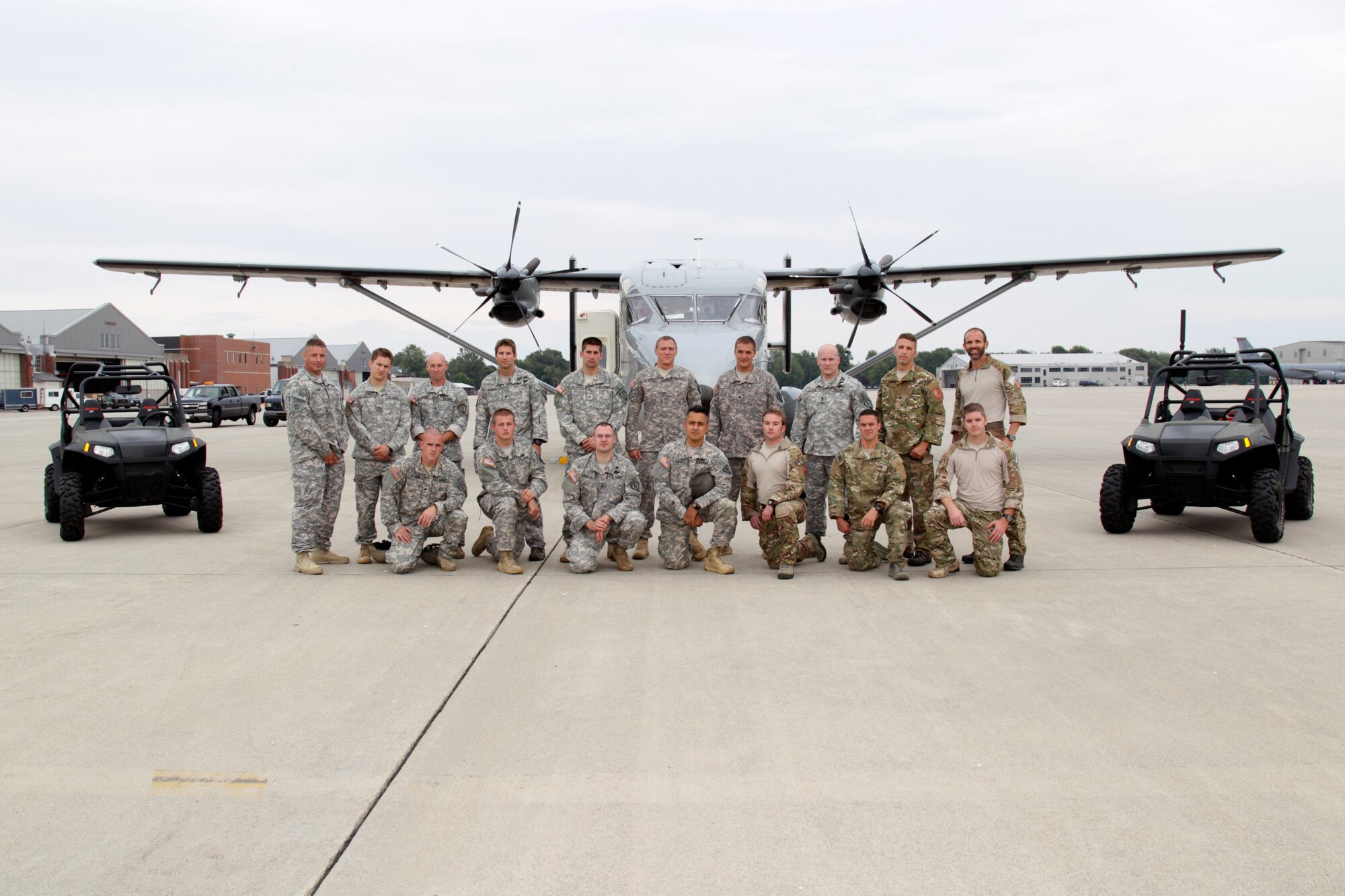 Airmen and Soldiers from two states stand by some of their equipment prior to spending a day in joint training at Selfridge Air National Guard Base, Mich., Aug. 13, 2012. The Soldiers are from C Company, 151st LRS and the 165th QM, from the Indiana Army National Guard. The Airmen are special operators from the 107th Weather Flight, Michigan Air National Guard. The Soldiers and Airmen spent a day conducting joint airborne operations, with each individual making several parachute jumps during the day. The training allowed the Soldiers and Airmen to maintain their proficiency in a variety of skill requirements. By training together, the Soldiers and Airmen are able to maximize training opportunities at a lower cost. (Air National Guard photo by SrA. Toni Stusse)