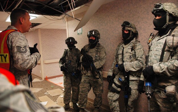 After the team was successful at taking out the shooter, Tech. Sgt. Ernist Surber gives them an after action report on what he observed during their individual drill. Sergeant Surber is a graduate of the two-week Active Shooter Instructor Course at Lackland Air Force Base, Texas. (Air Force photo by Micah Garbarino)