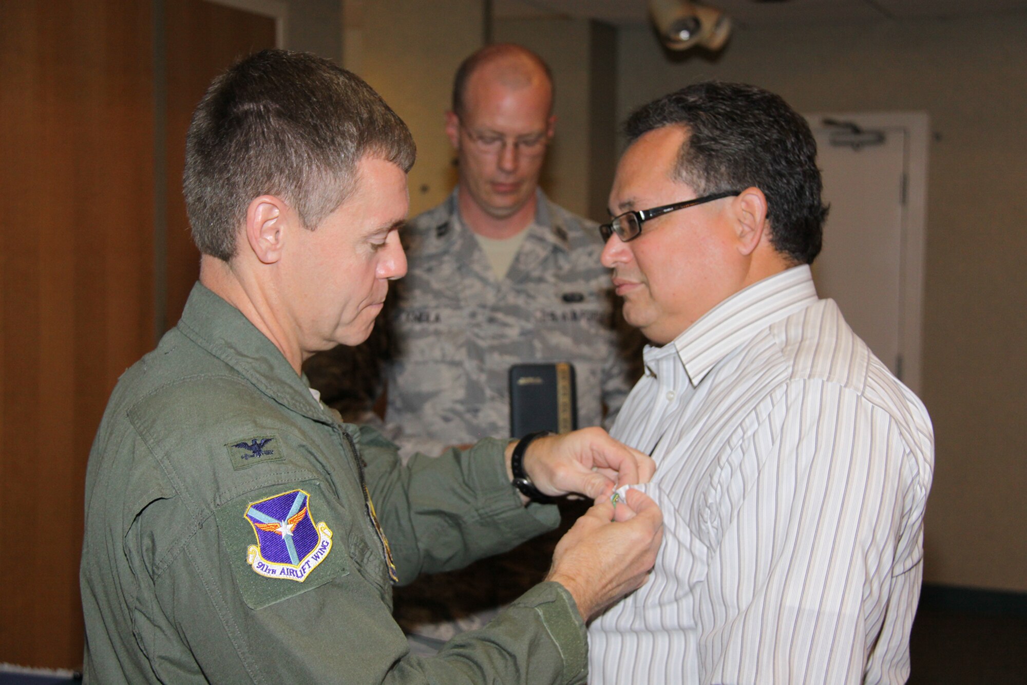 Col. Craig Peters, 911th Airlift Wing commander, pins on the Special Award for Exemplary Civilian Service to Anti-terrorism Officer, Justin Briley during the civilian commander’s call held Aug. 23, 2012. Briley displayed exceptional initiative and professionalism by developing and implementing a fully successful installation antiterrorism program as well as developed and implemented a model random antiterrorism measures program. He also compiled an active shooter awareness brief that was distributed command-wide and he effectively managed the AT Level l Awareness Training Compliance Program. He also assisted other Air Force Reserve Command installation ATOs in developing their AT programs as well. Col. Peters also awarded 16 other civilians for their excellent service and commitment to the 911th AW and the United States Air Force. (U.S Air Force photo by Master Sgt. Mark Winklosky/ Released)
