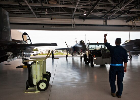 An Airman from the 33rd Maintenance Squadron directs an Air Force F-35A Lightning II into the 58th Fighter Squadron hangar at Eglin Air Force Base, Fla., Aug. 27.  The 33rd Fighter Wing’s joint strike fighters were moved into hangars in preparation for the arrival of Hurricane Isaac.  The 58th hangar held nine A models, while the Marine Fighter Attack Squadron 501 hangar stored the 10 B models.  (U.S. Air Force photo/Samuel King Jr.)  