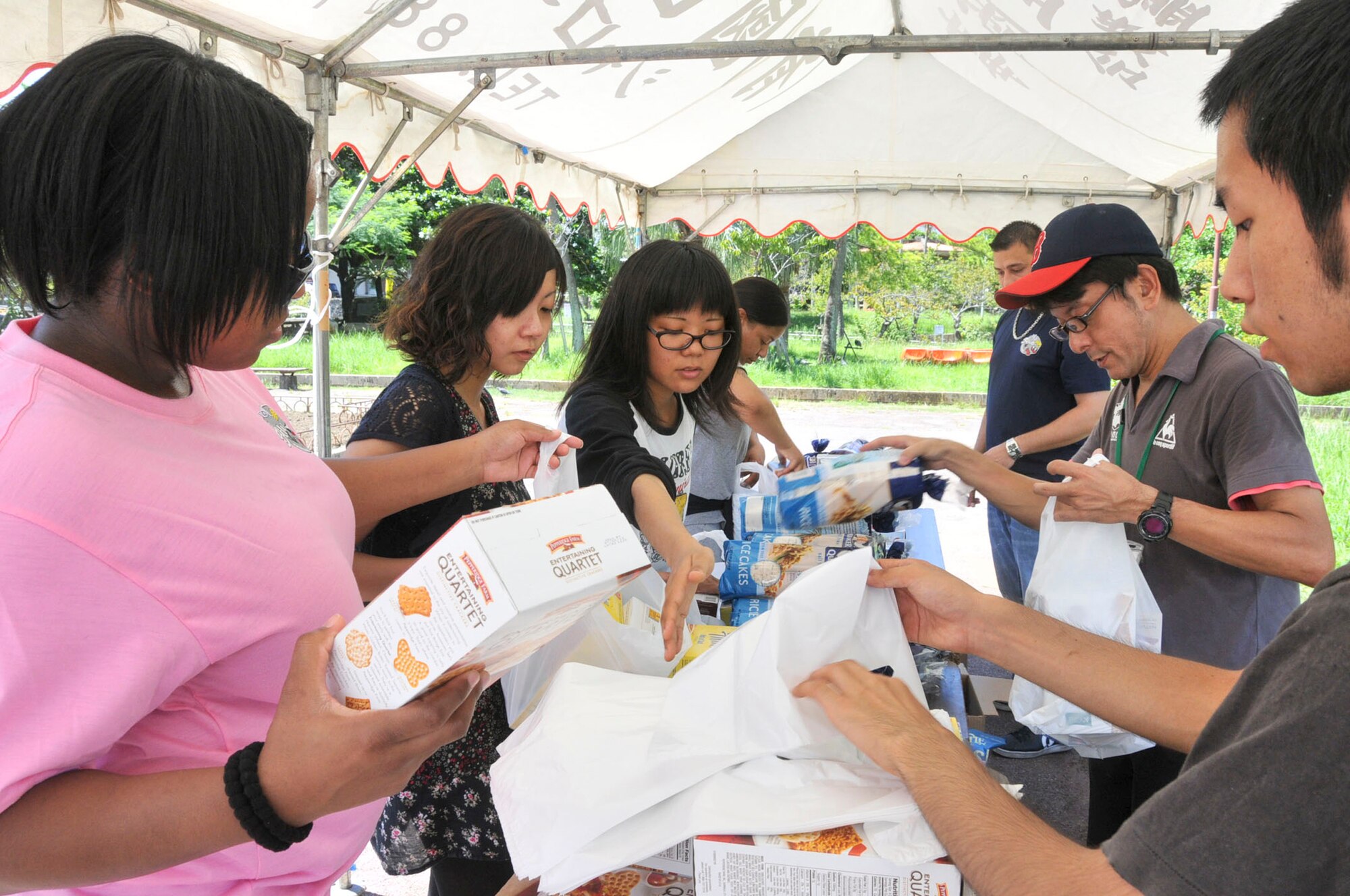 Local volunteers and Kadena 5/6 Club volunteers organize donations into to-go bags during a volunteer event to feed the homeless in Yogi Park in Naha, Okinawa, on Aug. 18, 2012. More than 200 less fortunate people were served food and drinks during this event. (U.S. Air Force photo/Staff Sgt. Darnell T. Cannady)