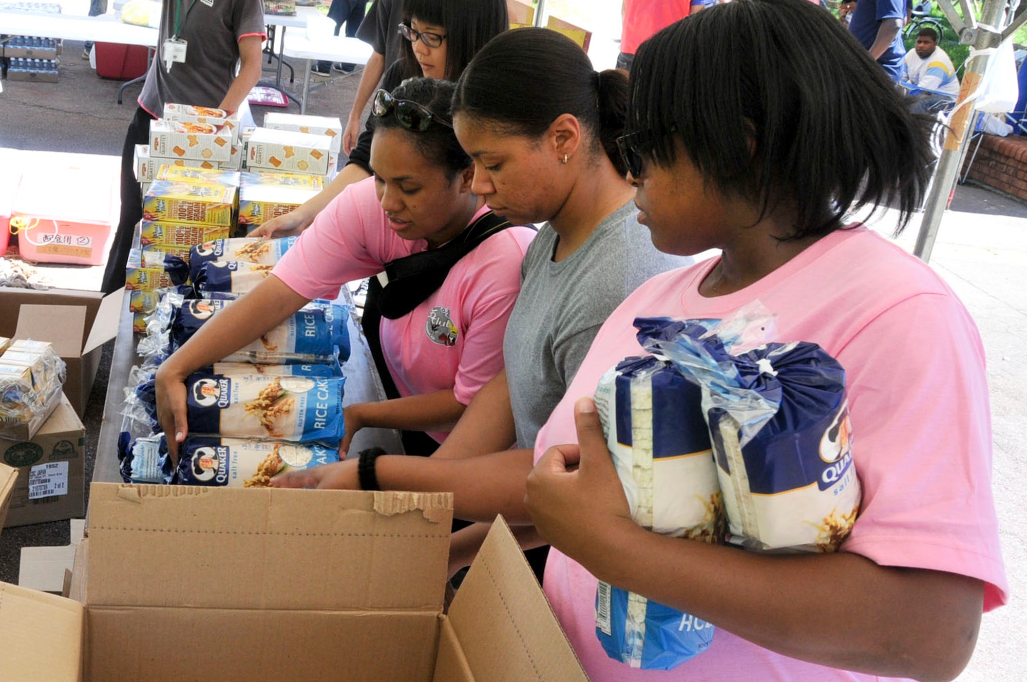 (From left to right) U.S. Air Force Staff Sgt. Patricia Feaster-Kimmerle, U.S. Air Force Staff Sgt. Tiffany Finks, and U.S. Air Force Staff Sgt. Charlene Rockett, all members of Kadena 5/6 Club, organize donated supplies into to-go bags during a volunteer event to feed the homeless in Naha's Yogi Park, Okinawa, on Aug. 18, 2012. These volunteers set up booths and provided food for 200 less fortunate people. (U.S. Air Force photo/Staff Sgt. Darnell T. Cannady)