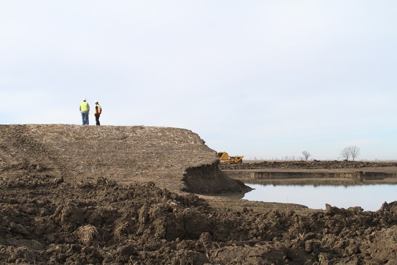 Contractors with Ideker, Inc. discuss levee repairs on top of the Wakenda Levee in Carroll County, Mo., on Feb. 1, 2012. The levee was breached during the Missouri River flooding in 2011. The contract was awarded by the U.S. Army Corps of Engineers Kansas City District on Jan. 23, 2012. A new drainage ditch was excavated, and the new portion of the levee was setback. U.S. Army Corps of Engineers photo by Diana McCoy.